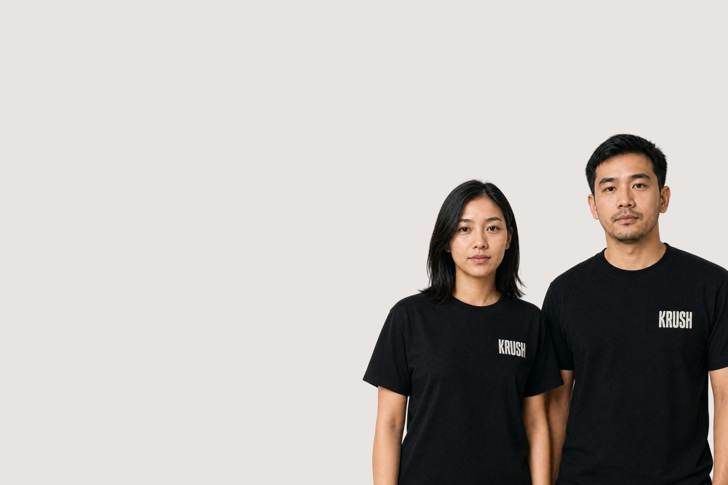KRUSH Bangkok crew portrait — two team members in black KRUSH tees against a bone wall